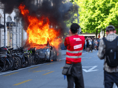 Anti-G7 protest turns violent as demonstrators torch Tesla and smash UN office windows